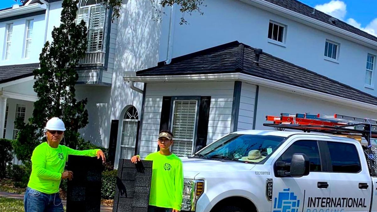 father son duo hold stone coated steel during the installation of stone coated steel in naples florida