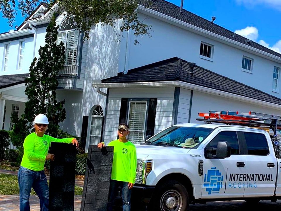 father son duo hold stone coated steel during the installation of stone coated steel in naples florida